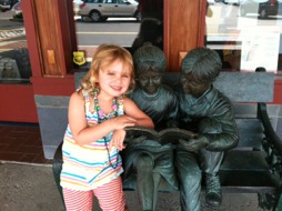 Young lover of books next to two other readers